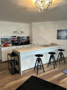 a kitchen with a white counter and stools at Ferienwohnung Ambiente 3 in Naumburg