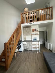 a room with a staircase and a kitchen with a table at 2 pièces duplex Issy Les Moulineaux in Issy-les-Moulineaux