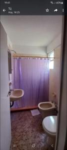 a bathroom with a purple shower curtain and a toilet at Torre 5 in Junín