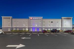 een groot gebouw met auto's geparkeerd op een parkeerplaats bij Best Western Plus Brunswick Inn & Suites in Brunswick