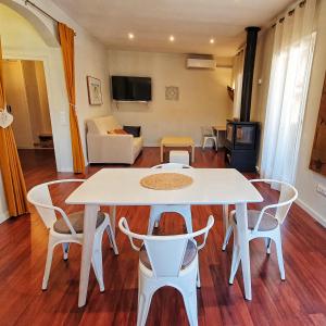 ein Wohnzimmer mit einem weißen Tisch und Stühlen in der Unterkunft Can Carreras de Sant Jaume in Sant Jaume de Llierca