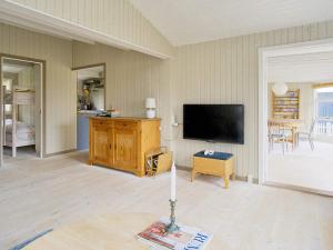 sala de estar con TV de pantalla plana y mesa en Holiday home Vejby XXVII, en Vejby