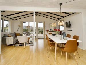 a dining room and living room with a table and chairs at Holiday home Ølsted III in Ølsted