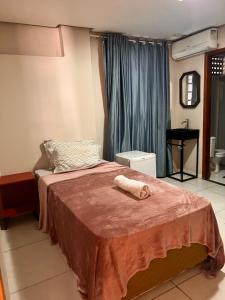 um quarto com uma cama com uma toalha em Suites Stival Centro em Goiânia