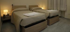 2 Betten in einem Hotelzimmer mit Handtüchern darauf in der Unterkunft Hotel Park Le Baleari in Tirrenia