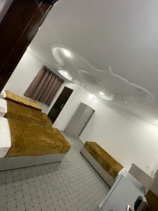 a room with two beds and a toilet in it at فندق العز بيتي in Al Madinah