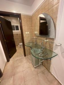 a bathroom with two sinks and a mirror at فندق العز بيتي in Al Madinah