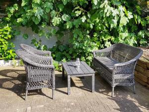 Duas cadeiras de vime, uma mesa e uma cadeira. em 4 person holiday home in S nderborg em Sonderborg