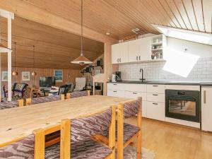 a kitchen and dining room with a large wooden table at 6 person holiday home in Ålbæk in Ålbæk