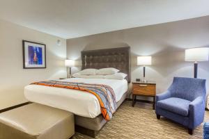 a bedroom with a large bed and a blue chair at Drury Inn and Suites St Louis Collinsville in Collinsville