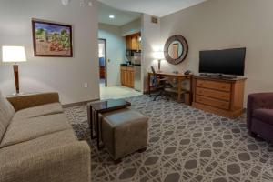 a living room with a couch and a flat screen tv at Drury Inn & Suites Las Cruces in Las Cruces