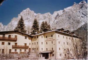 a building in front of a snow covered mountain at Casa Montana S. Maddalena in San Vito di Cadore