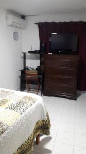 - une chambre avec un lit et une télévision sur une commode dans l'établissement APARTA-HOTEL YINNAM ARRIETA, à San Andrés