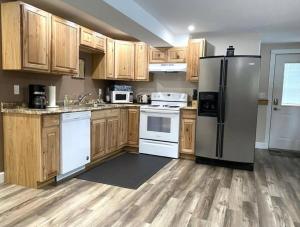 una cocina con electrodomésticos blancos y armarios de madera en Hot Tub-Mountain View-Secluded-Entire Private Floor en Seeley Lake