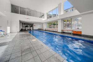 a large swimming pool with blue water in a building at Glorious Central Canberra 1-Bed with Pool & Sauna in Canberra