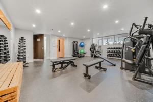 a gym with treadmills and machines in a room at Glorious Central Canberra 1-Bed with Pool & Sauna in Canberra