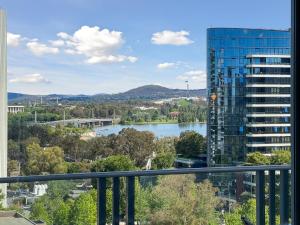 - une vue sur une rivière et un grand bâtiment dans l'établissement Glorious Central Canberra 1-Bed with Pool & Sauna, à Canberra