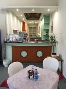 cocina con mesa, sillas y barra en Hotel Park Le Baleari en Tirrenia