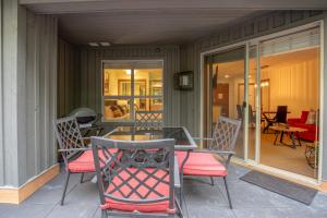 a patio with a table and chairs on a porch at Ski In Ski Out Apartment w Pool and Hot Tub by Harmony Whistler in Whistler