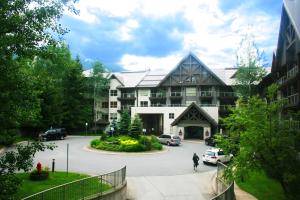 a large building with cars parked in a parking lot at Ski In Ski Out Apartment w Pool and Hot Tub by Harmony Whistler in Whistler