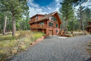 a large wooden house in the woods with a driveway at Rustic Ward Retreat with Deck and Mountain Views! in Ward