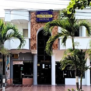 una casa imperial de hotel con palmeras delante en Hotel Imperial House, en Barranquilla