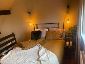 a bed in a bedroom with two lights on the wall at New, unique, tiny house with garden in Wigston Magna