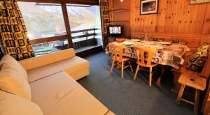 a dining room with a table and chairs and a couch at Résidence Palafour - Studio pour 4 Personnes 221 in Tignes