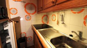 cocina con fregadero y pared de azulejos en Résidence Palafour - Studio pour 4 Personnes 221 en Tignes