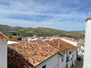 a view of roofs of buildings with mountains in the background at Apartamento Isabel in Ardales