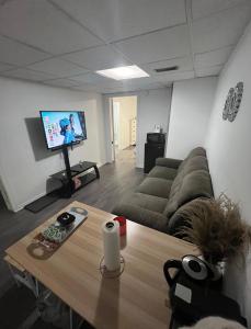 ein Wohnzimmer mit einem Sofa und einem Tisch in der Unterkunft Elegant Private Room in Oshawa