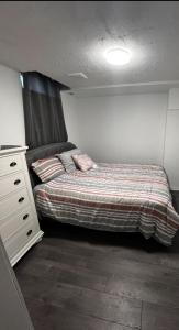 ein Schlafzimmer mit einer Kommode und einem Bett sidx sidx sidx sidx sidx in der Unterkunft Elegant Private Room in Oshawa