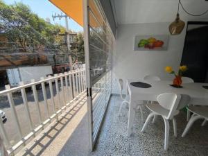 einen weißen Tisch und Stühle auf einem Balkon mit Aussicht in der Unterkunft nice apt. Roma CDMX :) in Mexiko-Stadt