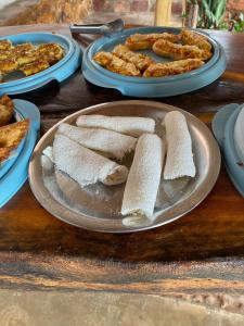 una mesa con un plato de pan y platos de comida en Villa Manga Rosa, en Lençóis