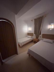 Habitación de hotel con 2 camas y ventana en Tokyo House en Dahab