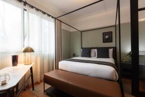 a bedroom with a bed and a desk and a window at Hotel Edificio Republica in Mexico City
