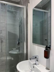 y baño con lavabo, ducha y espejo. en Cony’s Guest House, en Kwabenyan
