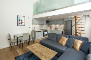 sala de estar con sofá, mesa y cocina en Kensington Arte Casa, en Londres