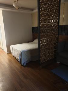 a bedroom with a bed and a wooden floor at Luxury Studio Apprtement in Hurghada