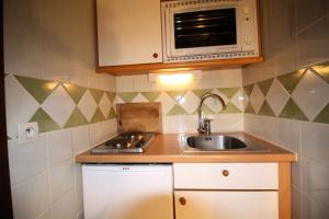 a small kitchen with a sink and a microwave at Résidence Palafour - Studio pour 2 Personnes 361 in Tignes
