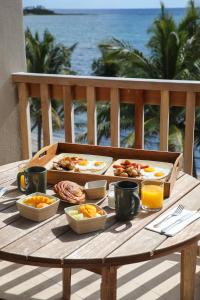 a wooden table with breakfast food on a balcony at Alea Tulum in Tulum