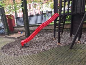 een rode glijbaan op een speelplaats in een park bij Penzion Nové dvory in Kutná Hora
