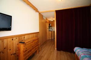 a room with a tv on the wall and a bedroom at Résidence Palafour - Studio pour 2 Personnes 371 in Tignes