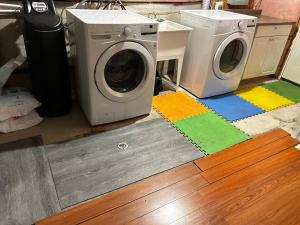 een wasruimte met een wasmachine en een wasmachine bij Cozy room D in Kitchener