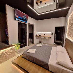 - une chambre avec un grand lit et une télévision à écran plat dans l'établissement Dark & Light rooms & luxury suites, à Catane