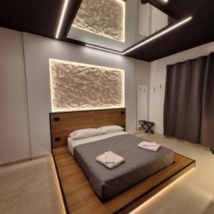 - une chambre avec un grand lit et 2 serviettes dans l'établissement Dark & Light rooms & luxury suites, à Catane