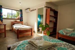 a bedroom with two beds and a mirror in it at Hotel Swell Pavones in Pavones