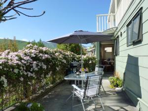 eine Terrasse mit einem Tisch und einem Sonnenschirm in der Unterkunft Ligita's Homestay in Havelock