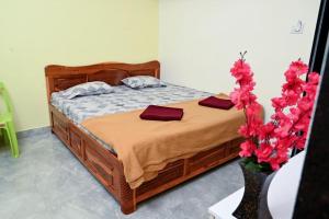 a bedroom with a bed and a vase with flowers at Anant Villa Chaul Alibaug Near Nagav Revdanda Beach in Alibag