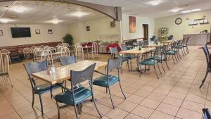 a restaurant with tables and chairs in a room at Lacombe Motor Inn in Lacombe